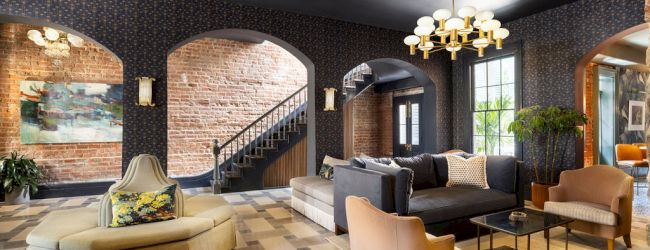 A stylish room features modern furniture, brick walls, and unique lighting, giving it a cozy yet sophisticated atmosphere.